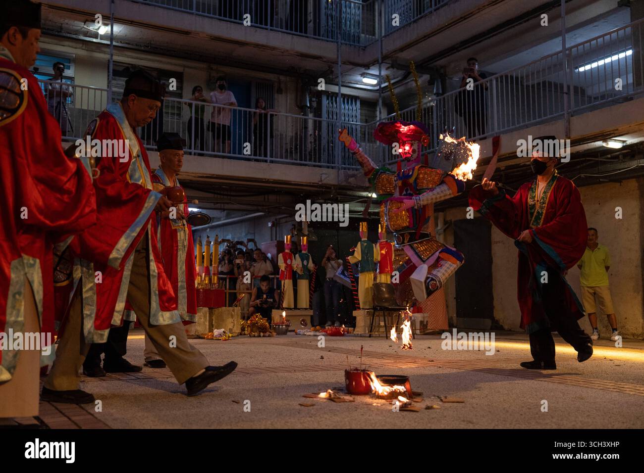 Hong Kong Ghost Festival in Public Housing Estate Ein taoistischer Priester, der am 31. August 2025 in Hong Kong Ein Schwert in Flammen hält, während er das Break Hell s Gate oder das letzte Tanzritual beim Geisterfestival im Wah Fu Estate vorstellt. Foto von Vernon Yuen/Nexpher Images Stockfoto