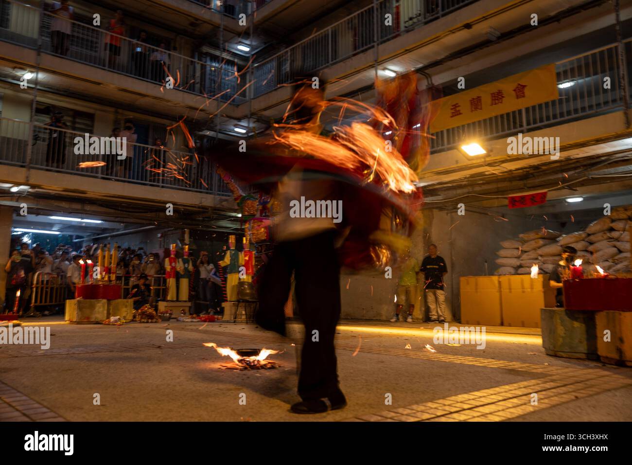 Hong Kong Ghost Festival in Public Housing Estate Ein taoistischer Priester, der am 31. August 2025 in Hong Kong Ein Schwert in Flammen hält, während er das Break Hell s Gate oder das letzte Tanzritual beim Geisterfestival im Wah Fu Estate vorstellt. Foto von Vernon Yuen/Nexpher Images Stockfoto
