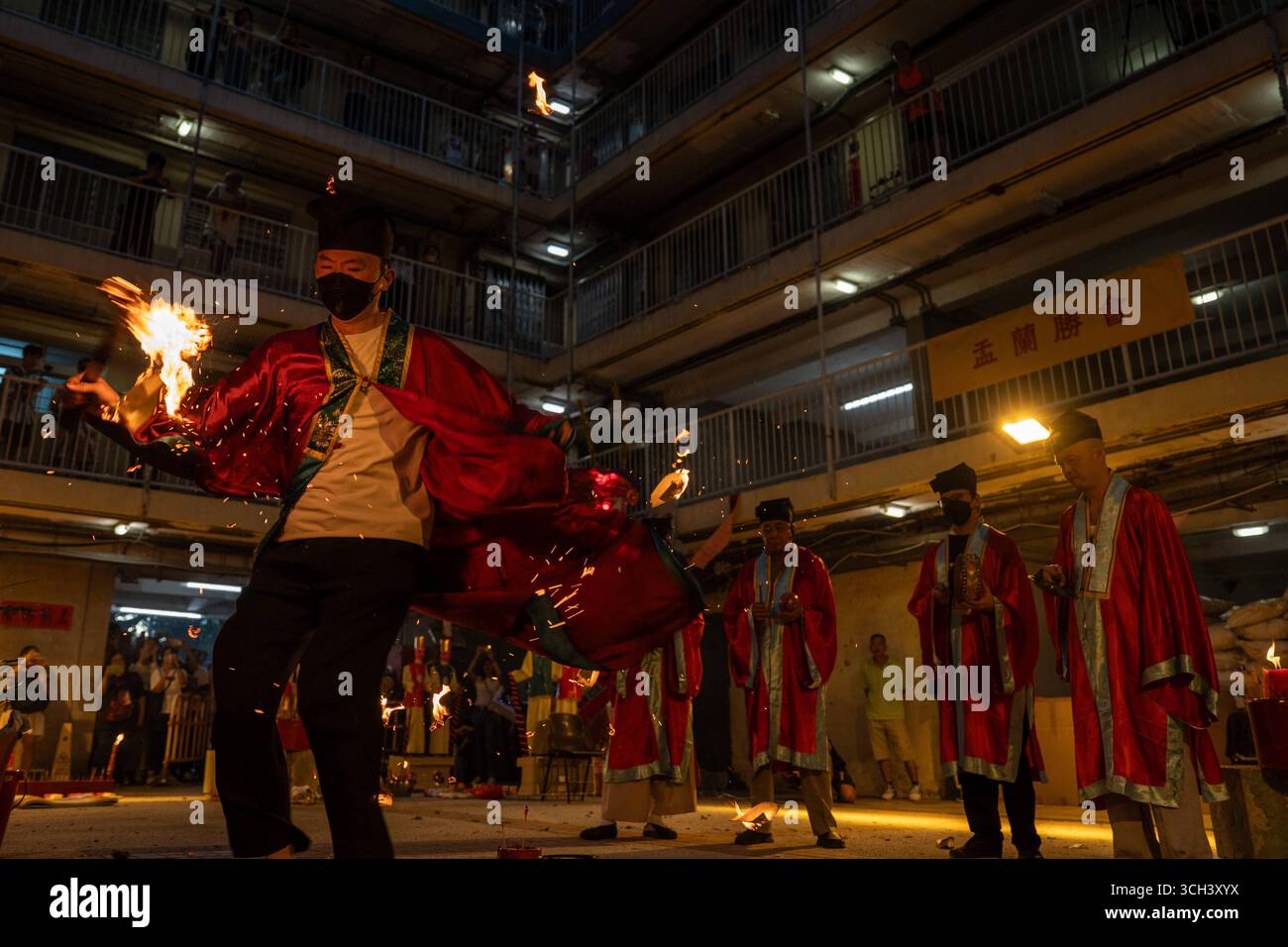 Hong Kong Ghost Festival in Public Housing Estate Ein taoistischer Priester, der am 31. August 2025 in Hong Kong Ein Schwert in Flammen hält, während er das Break Hell s Gate oder das letzte Tanzritual beim Geisterfestival im Wah Fu Estate vorstellt. Foto von Vernon Yuen/Nexpher Images Stockfoto