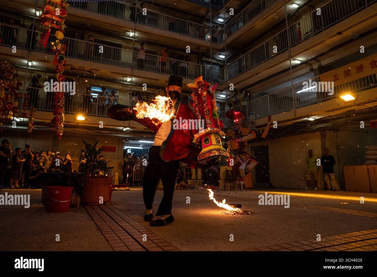 Hong Kong Ghost Festival in Public Housing Estate Ein taoistischer Priester, der am 31. August 2025 in Hong Kong Ein Schwert in Flammen hält, während er das Break Hell s Gate oder das letzte Tanzritual beim Geisterfestival im Wah Fu Estate vorstellt. Foto von Vernon Yuen/Nexpher Images Stockfoto