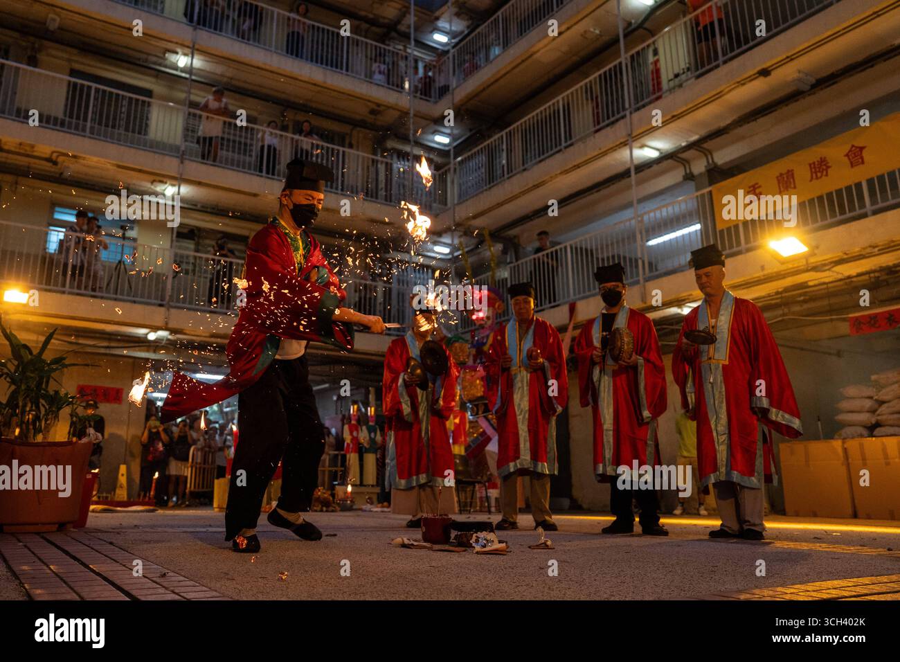 Hong Kong Ghost Festival in Public Housing Estate Ein taoistischer Priester, der am 31. August 2025 in Hong Kong Ein Schwert in Flammen hält, während er das Break Hell s Gate oder das letzte Tanzritual beim Geisterfestival im Wah Fu Estate vorstellt. Foto von Vernon Yuen/Nexpher Images Stockfoto