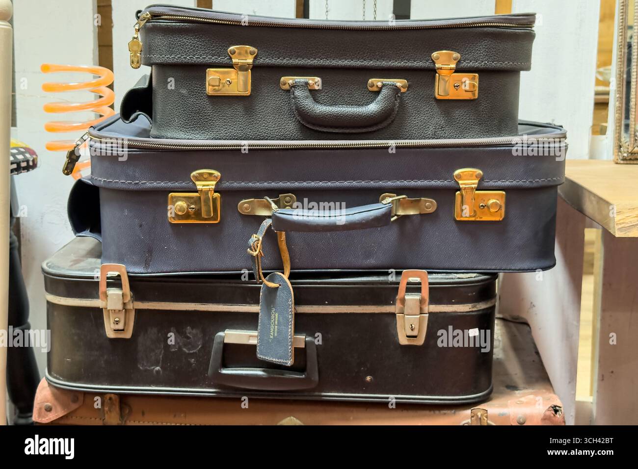 Stapel von Vintage-Koffern mit Metallverschlüssen in einem Second-Hand-Shop. Umweltbewusstes Einkaufen, Wiederverwertung, nachhaltiges Reisen, Abfall Stockfoto