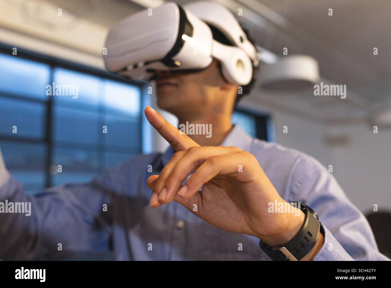 Mit dem VR-Headset interagiert der Mann in modernen Büros mit virtueller Umgebung Stockfoto