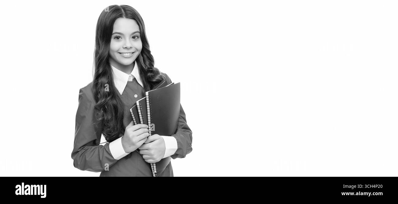 Fröhliches Kind langes lockiges Haar halten Schularbeitsbuch isoliert auf weiß, Bildung. Banner einer Schülerin. Schülerporträt mit Kopie Stockfoto