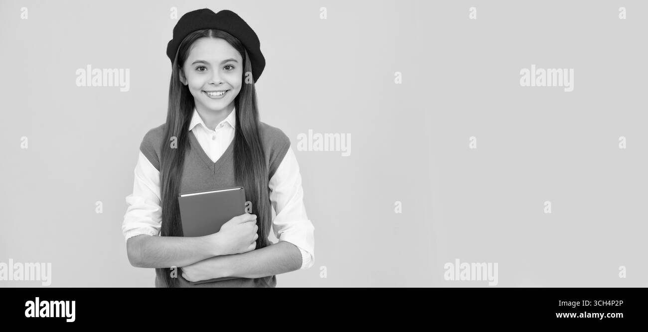 Lernprüfung. Fröhliches Kind in Baskenmütze bereit zum Lernen. Lächelndes Kind mit Buch. Porträt einer Schülerin, Studio-Banner-Header. Gesicht des Schulkindes Stockfoto