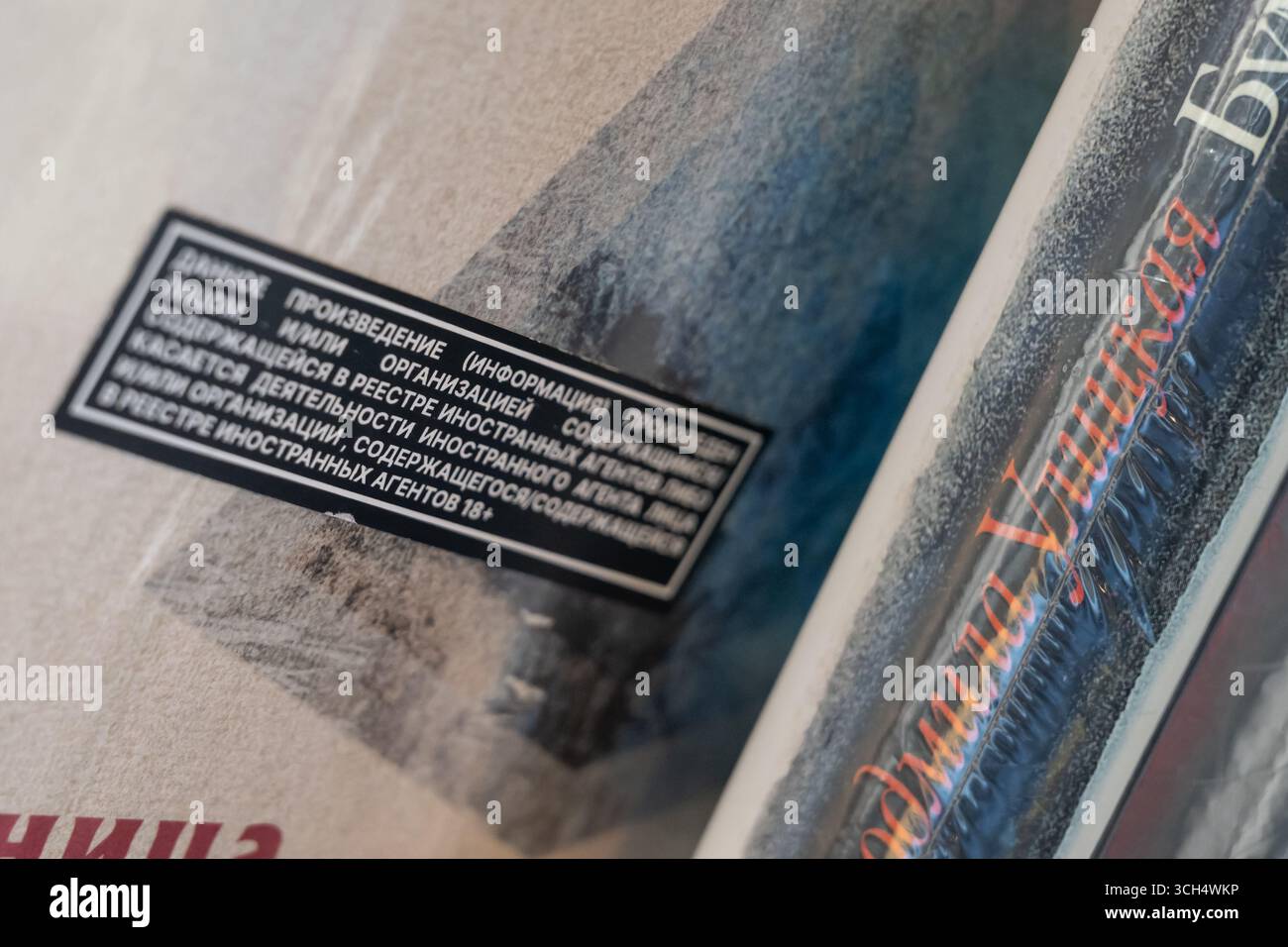 Ein Buch, das mit einem Etikett ausländischer Agenten gekennzeichnet ist, das besagt, dass das Material von einem ausländischen Agenten hergestellt wurde, liegt im Rahmen eines Verkaufs in der Buchhandlung „Podpisnye Izdaniya“ auf einem Regal. Ab dem 1. September 2025 treten in Russland Änderungen der föderalen Gesetzgebung in Kraft, die ausländischen Agenten die Teilnahme an Bildungs- und Aufklärungsaktivitäten verbieten. Obwohl das Gesetz den Verkauf von Büchern durch Autoren mit diesem Status nicht ausdrücklich verbietet, ziehen es Buchhändler vor, auf der Seite der Vorsicht Fehler zu machen und entfernen solche Produkte bereits aus Regalen und Katalogen. Stockfoto