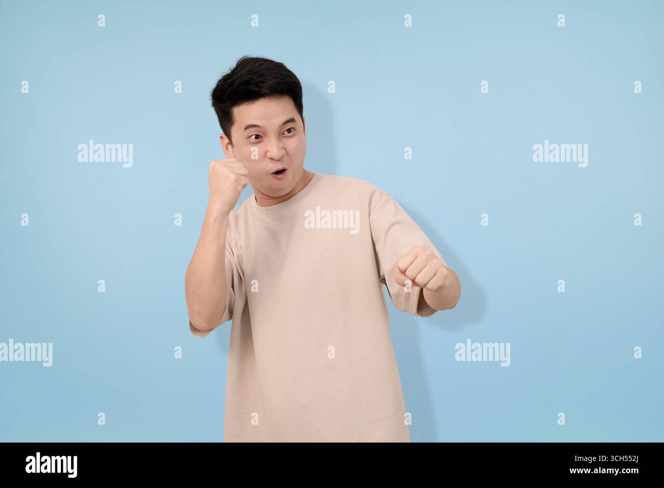 Junger Mann mit Gesten im Studio im blauen Hintergrund Stockfoto