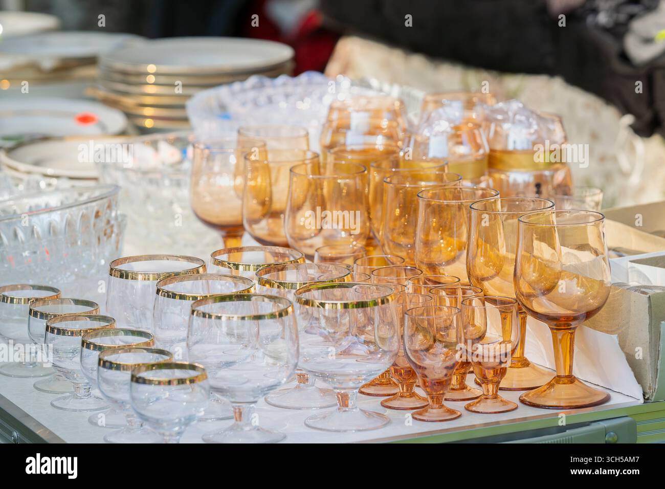 Flohmarkt-Theke mit Vintage-Glasgläsern, Schüsseln und anderen alten Dingen. Verschiedene Antiquitäten auf dem Flohmarkt. Stockfoto