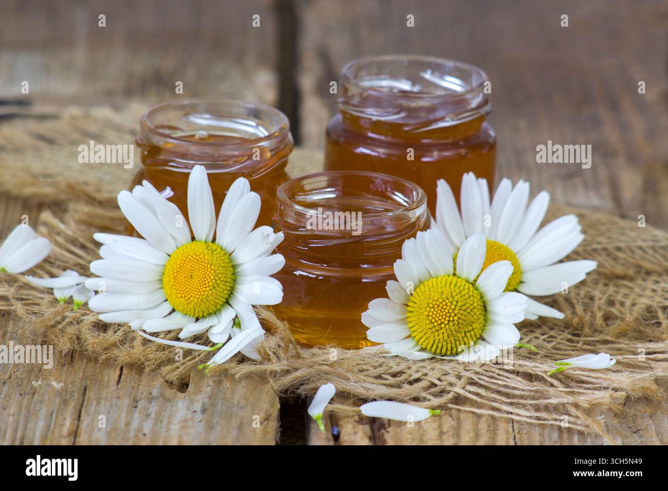 Honig und Blumen auf Holzhintergrund Stockfoto