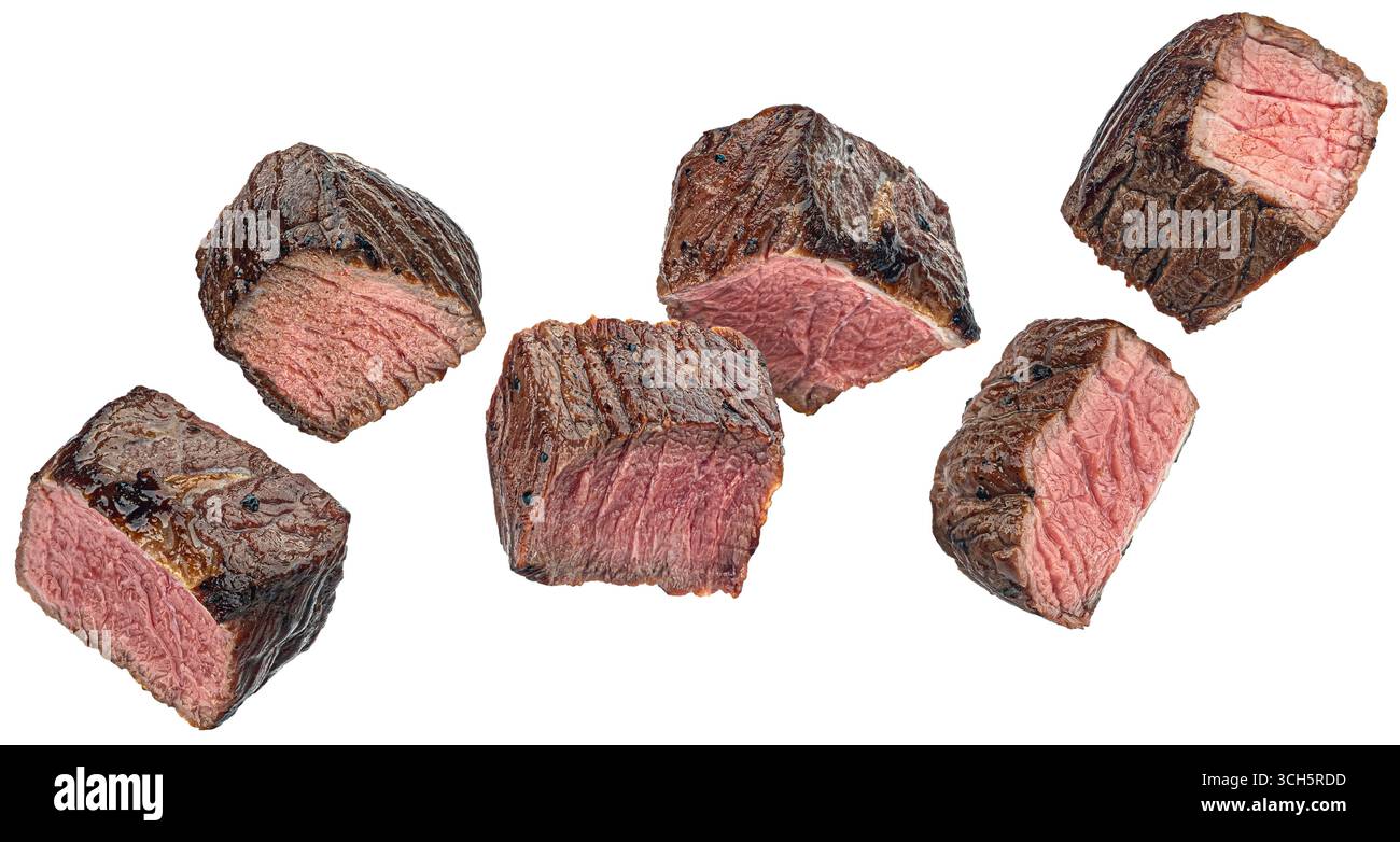 Mittelseltene Steakstücke, geschnittene gegrillte Rindfleischwürfel auf weißem Hintergrund Stockfoto