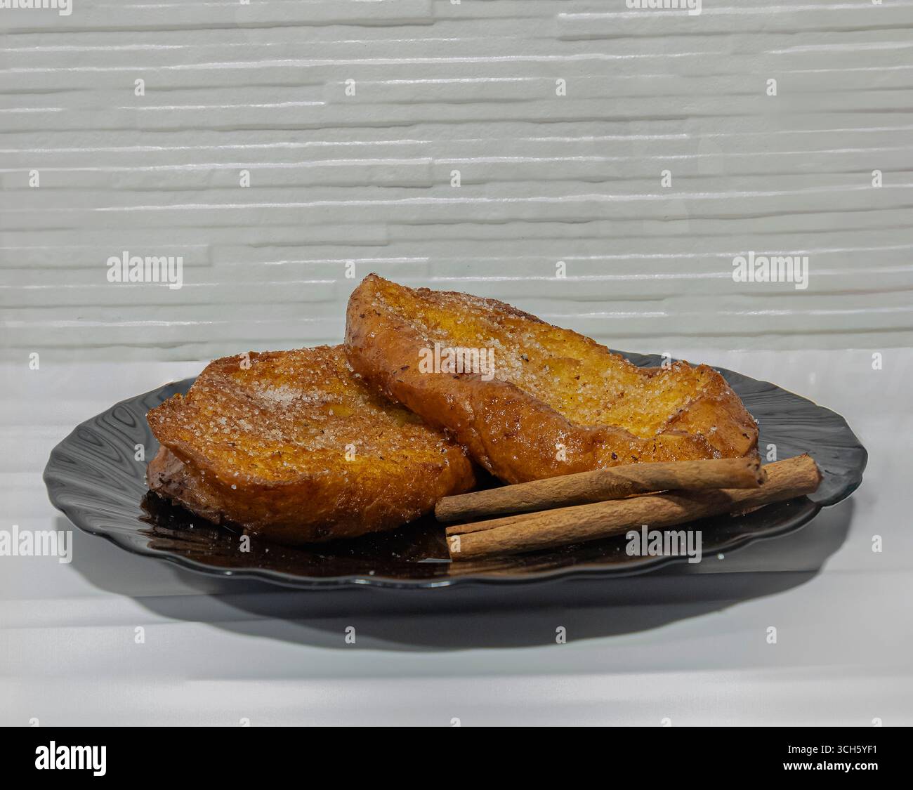 Traditioneller spanischer Torrijas mit Zimt – Ostersüß auf schwarzer Platte Stockfoto