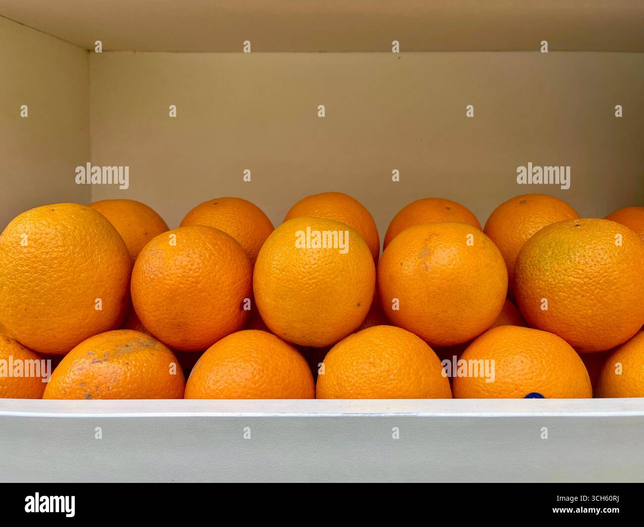 Frische Orangen in der weißen Box. Vorderansicht und sauberer Hintergrund - Smartphone-aufgenommenes Stockfoto