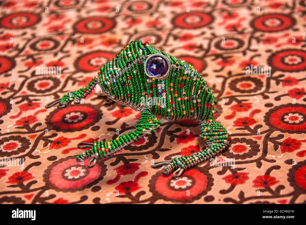 Perlen Froschdraht Skulptur, grüne Perlen mit blauen Augen, traditionelle afrikanische Kunstfiguren Stockfoto