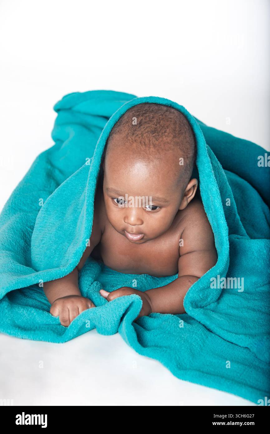 afrikanisches Baby auf dem Boden blaue Decke isoliert auf weißem Hintergrund Stockfoto