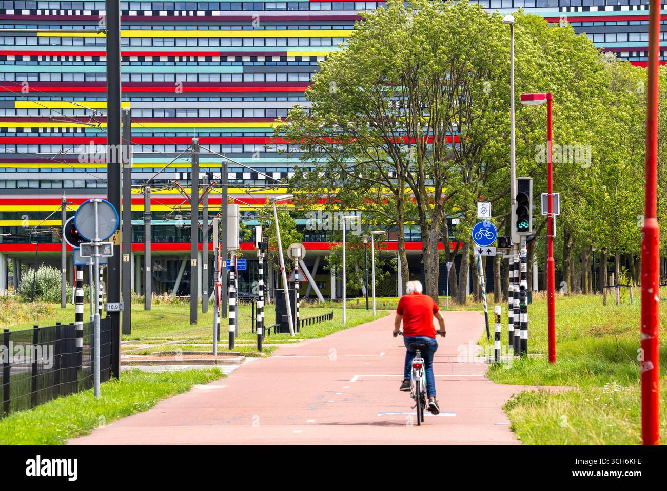 Radweg durch das Universitätsgelände im Wissenschaftspark Utrecht, Universität Utrecht, farbenfrohe Fassade des Hogeschool Utrecht Gebäudes, Netherlan Stockfoto