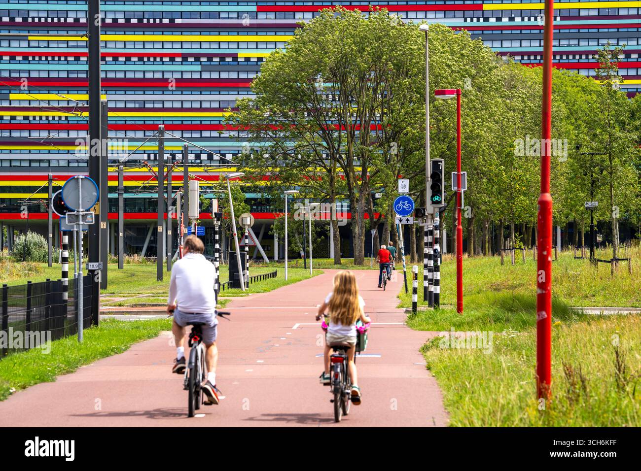Radweg durch das Universitätsgelände im Wissenschaftspark Utrecht, Universität Utrecht, farbenfrohe Fassade des Hogeschool Utrecht Gebäudes, Netherlan Stockfoto