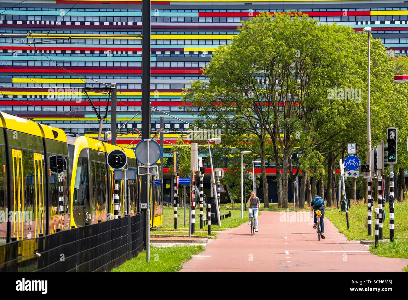 Radweg durch das Universitätsgelände im Wissenschaftspark Utrecht, Universität Utrecht, farbenfrohe Fassade des Hogeschool Utrecht Gebäudes, Netherlan Stockfoto