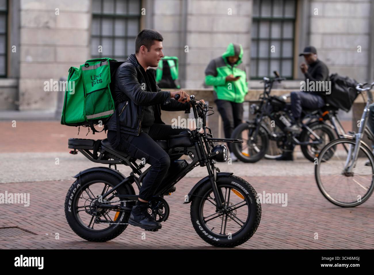 Fahrradverkehr in Groningen, Uber Eats, Kurierfahrer mit E-Bike im Mopedstil, Fatbike, Niederlande, Stockfoto