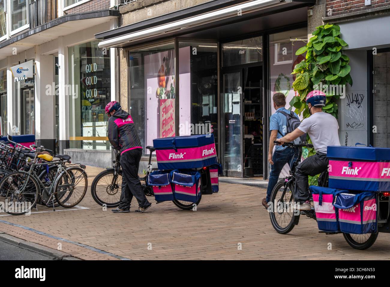 Radfahren im Stadtzentrum von Groningen, Altstadt, Zweigstelle des Lebensmittellieferdienstes Flink, Niederlande, Stockfoto