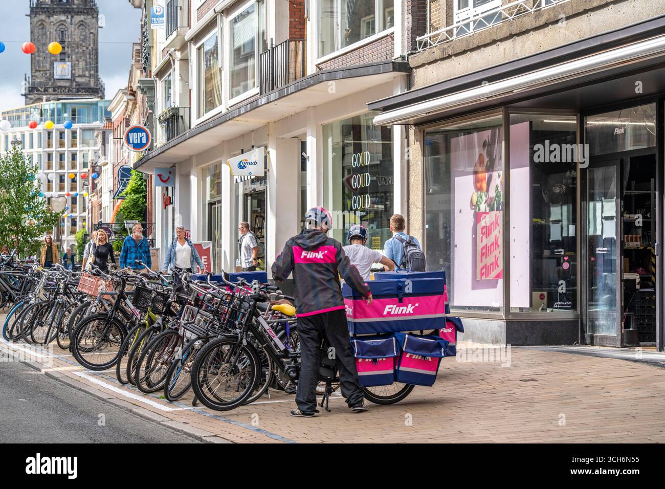 Radfahren im Stadtzentrum von Groningen, Altstadt, Zweigstelle des Lebensmittellieferdienstes Flink, Niederlande, Stockfoto