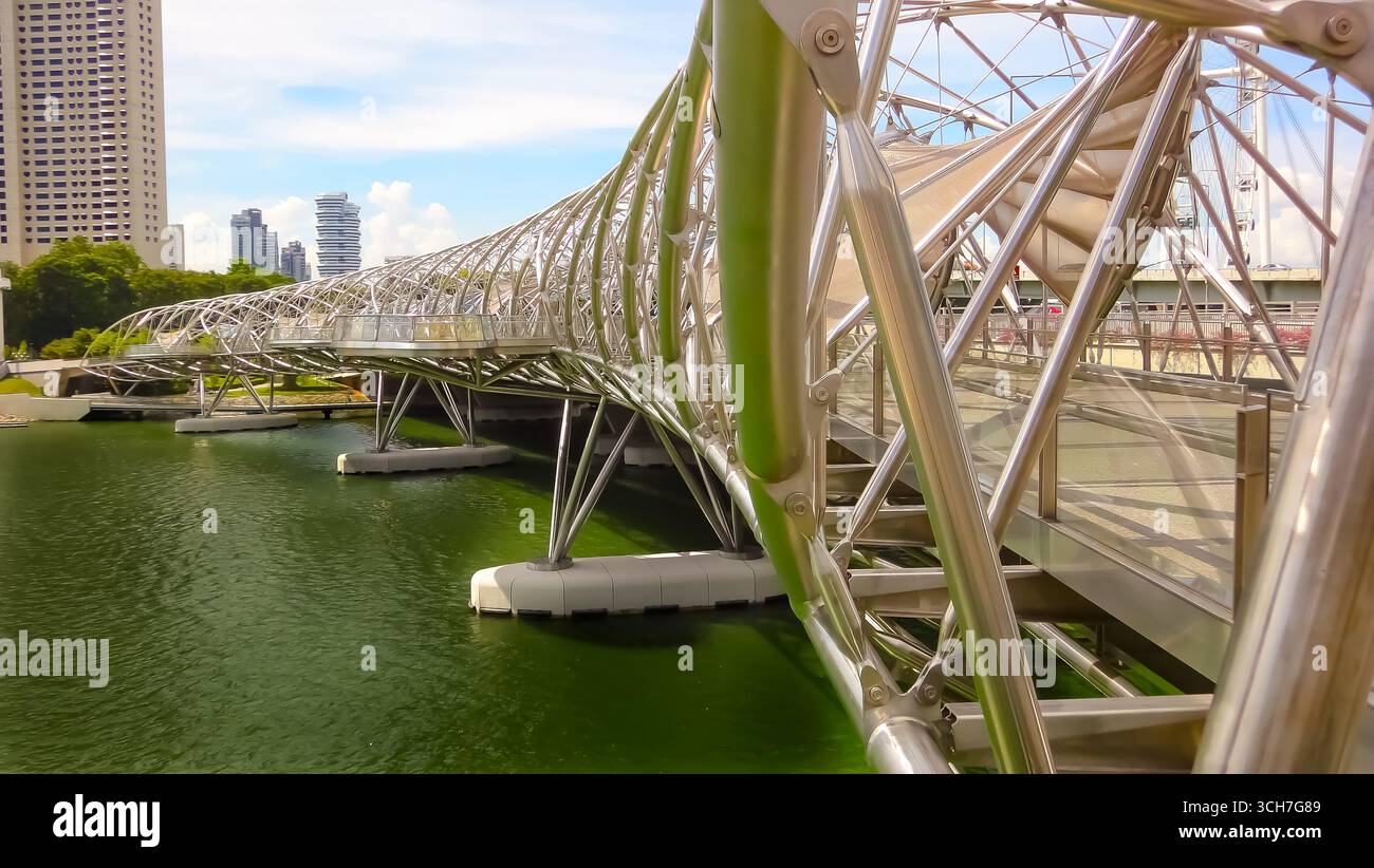 Die Helix Bridge in Singapur, eine ikonische Fußgängerbrücke mit einer unverwechselbaren Doppelspirale, fotografiert an einem sonnigen Tag. Stockfoto