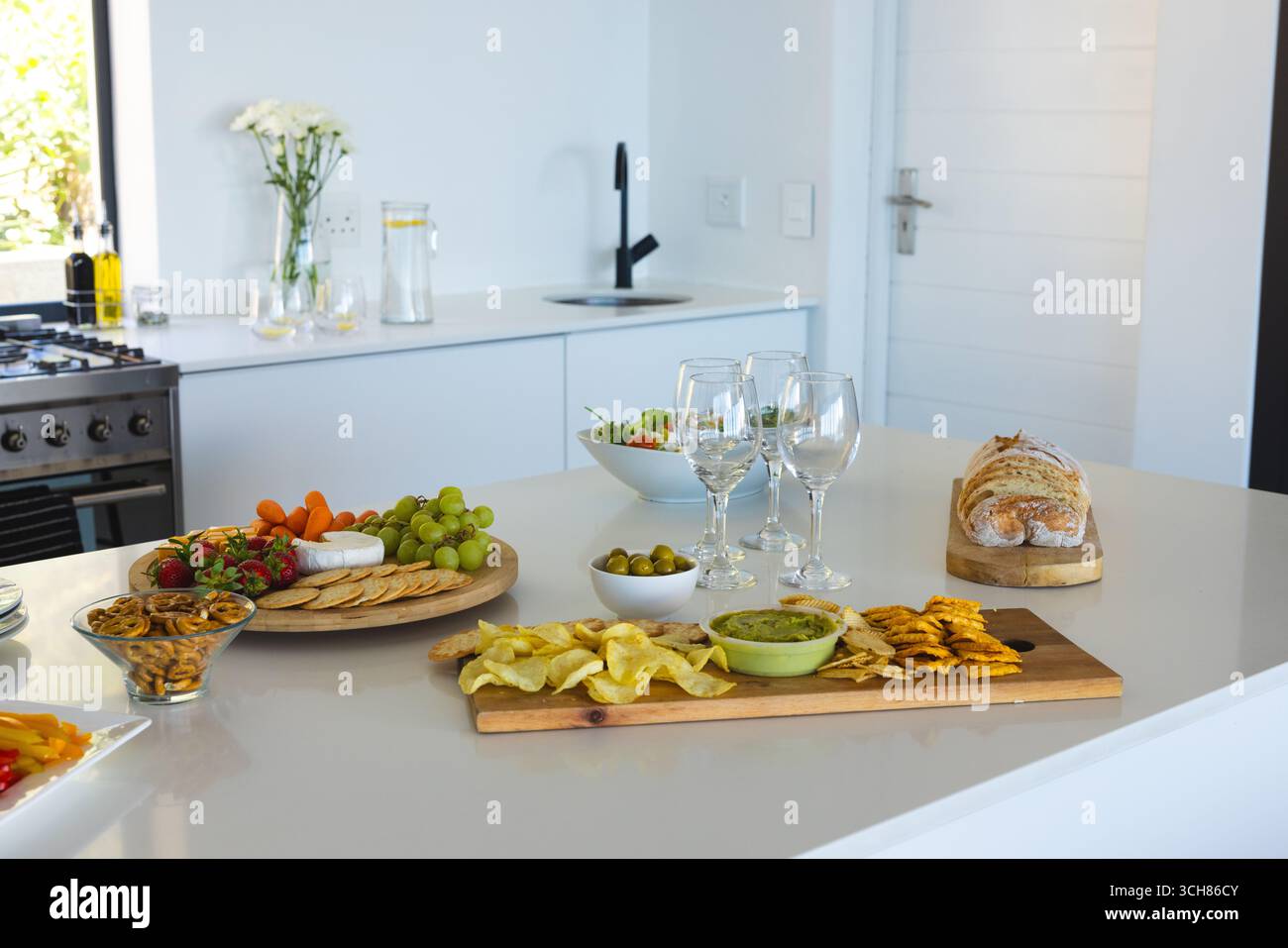 Vorspeisen, frisches Obst und Weingläser, elegante Küchenzeile zum Feiern Stockfoto