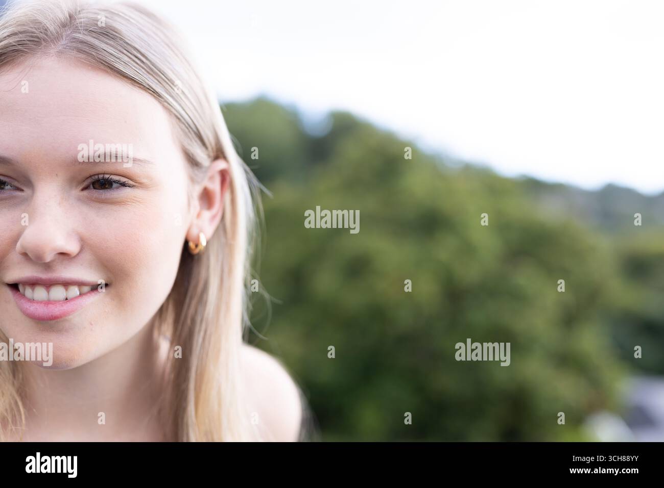 Teenager lächelt draußen, genießt die Natur und die frische Luft im Park Stockfoto