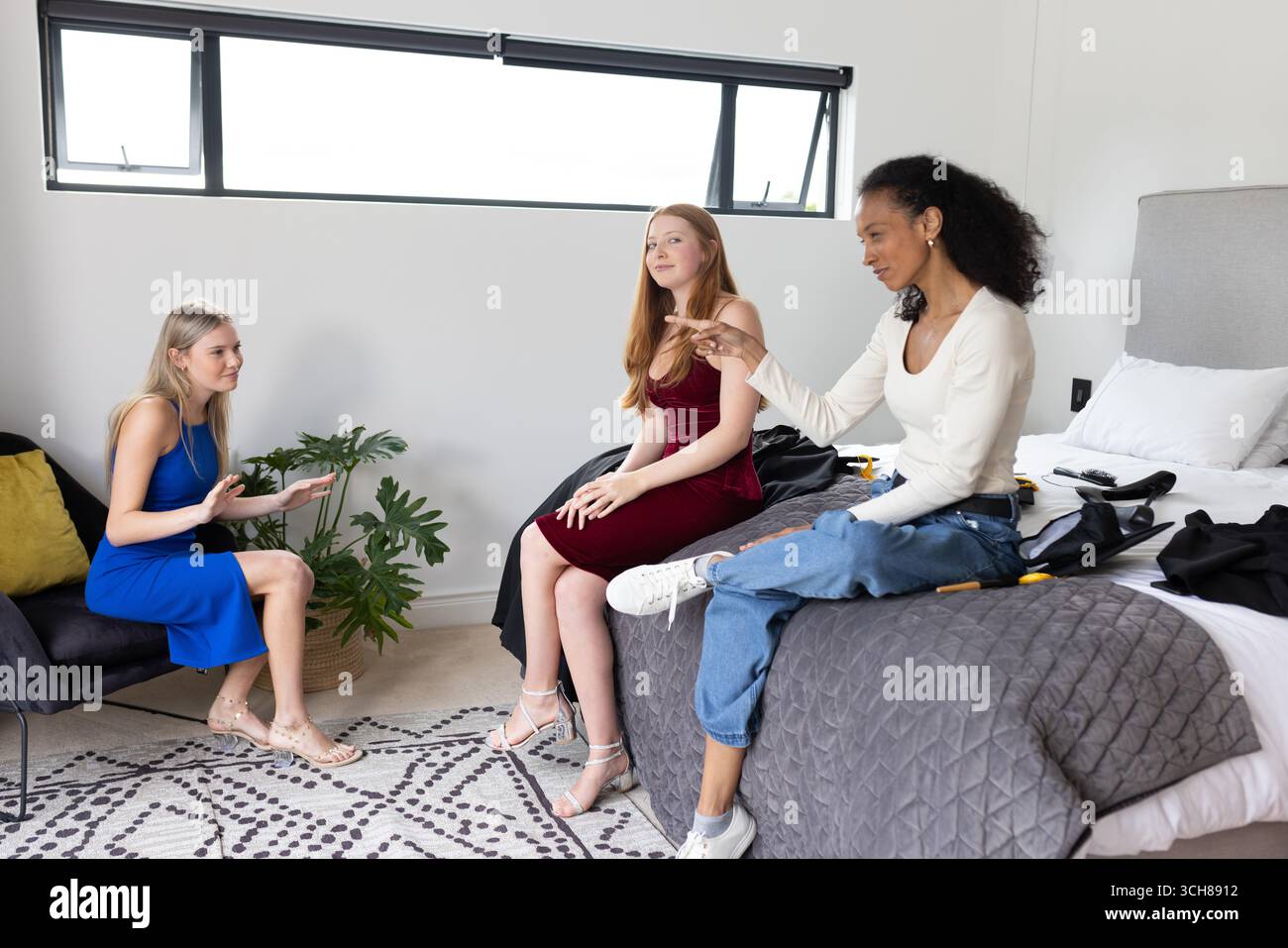 Teenager-Mädchen im Schlafzimmer diskutieren über Outfits, bereiten sich mit Begeisterung auf die Feier vor Stockfoto