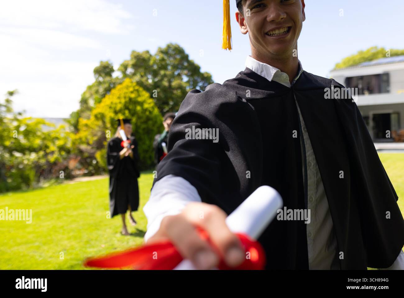 Diplom halten, Absolvent lächeln im Freien, um akademische Leistungen mit Freunden zu feiern Stockfoto