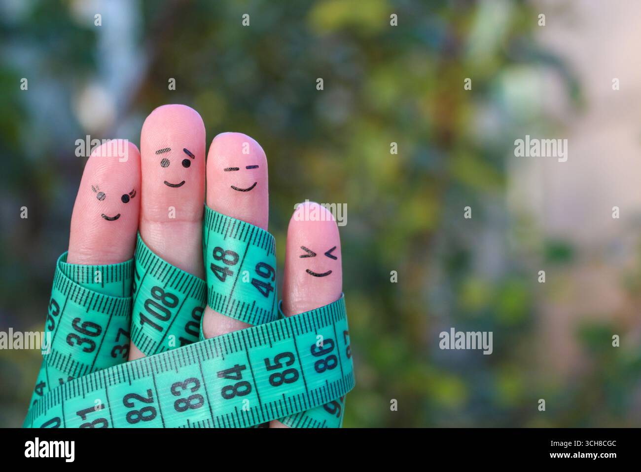 Fingerkunst einer glücklichen Familie mit Bandmaß. Das Konzept des gemeinsamen Abnehmens Stockfoto