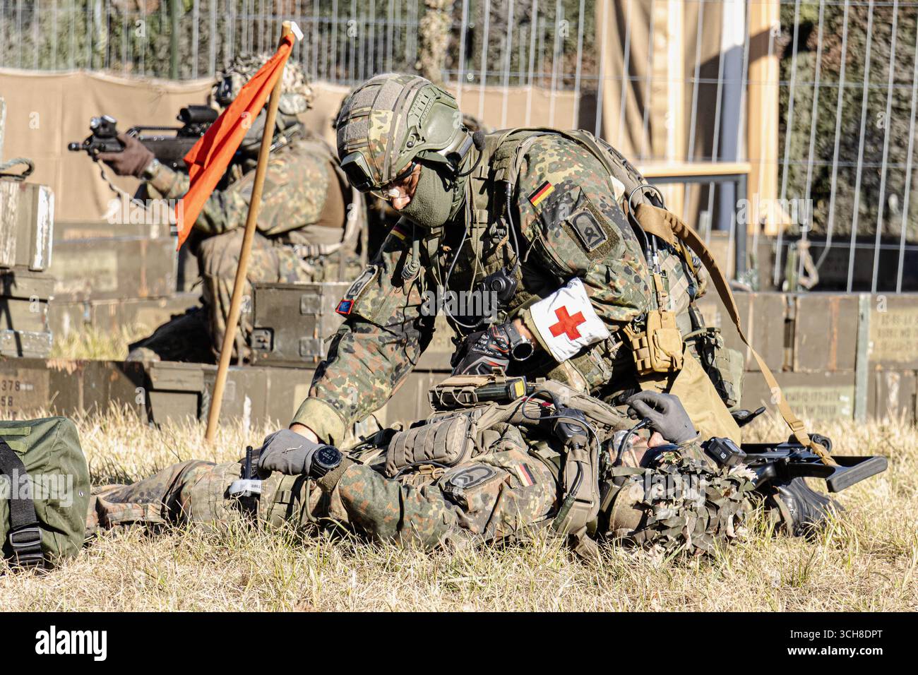 Fallschirmjäger der Bundeswehr in Kampfausrüstung nehmen an einer Trainingsübung teil, bei der ein verwundeter Soldat unterstützt und evakuiert wird Stockfoto
