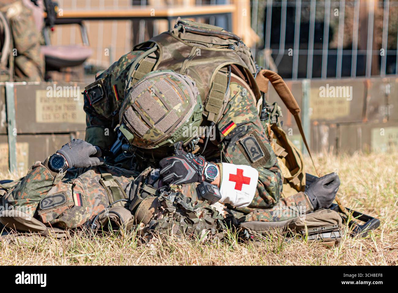 Fallschirmjäger der Bundeswehr in Kampfausrüstung nehmen an einer Trainingsübung teil, bei der ein verwundeter Soldat unterstützt und evakuiert wird Stockfoto