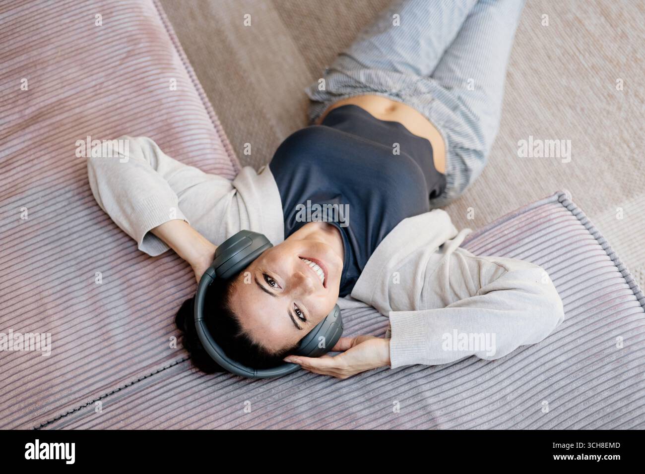 Frau, die sich zu Hause entspannt, Musik nach der Arbeit genießt. Stockfoto