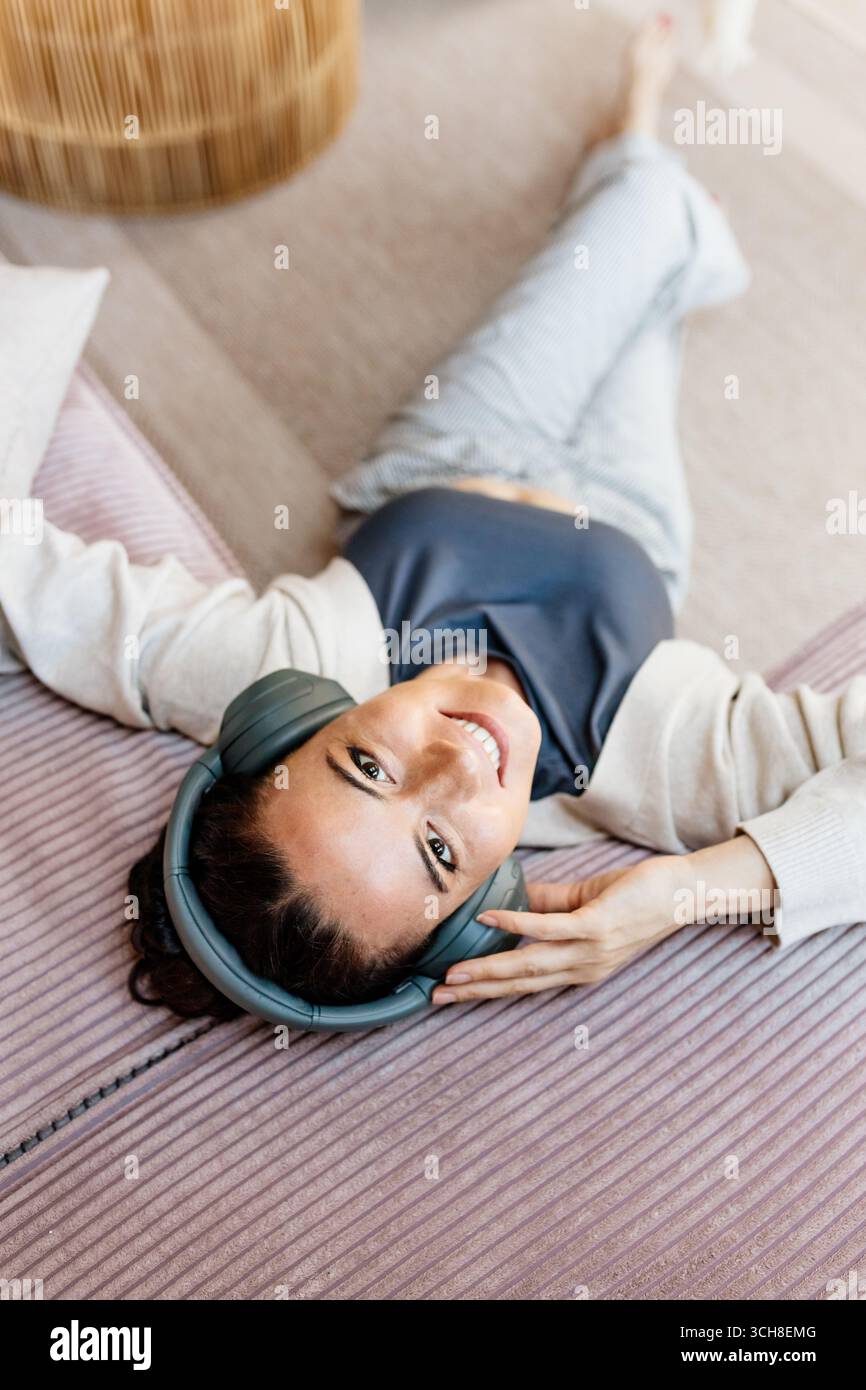 Frau, die sich zu Hause entspannt, Musik nach der Arbeit genießt. Stockfoto