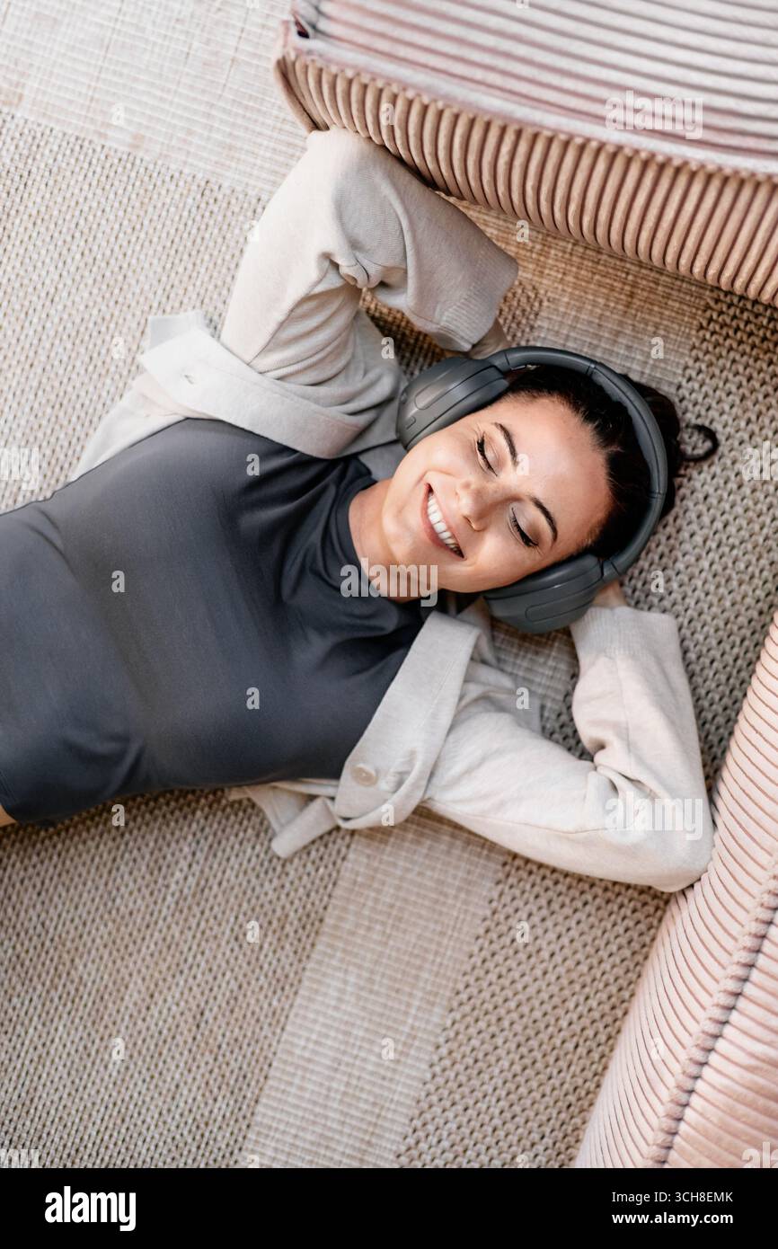 Frau, die sich zu Hause entspannt, Musik nach der Arbeit genießt. Stockfoto