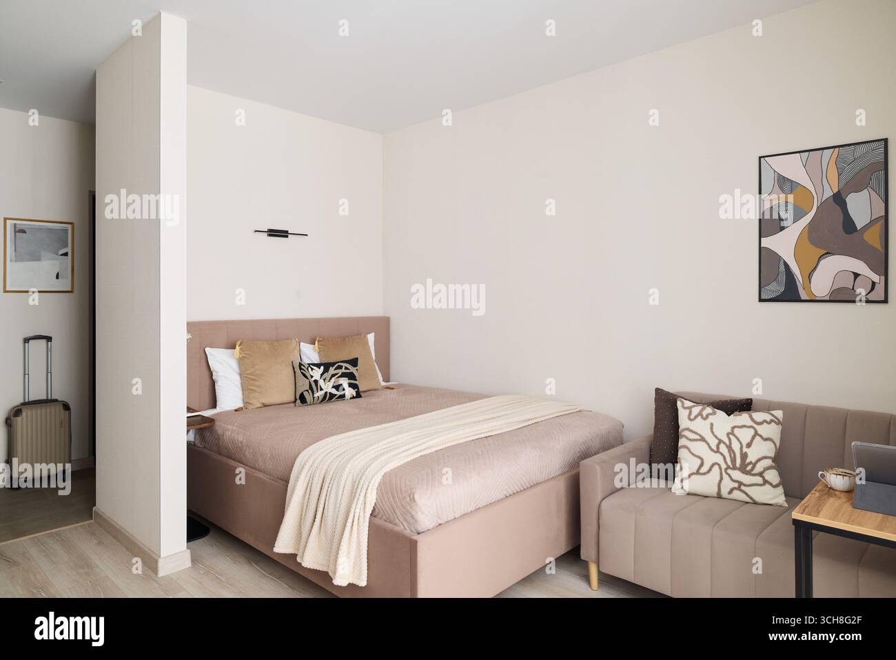 Ein schönes, modernes Schlafzimmer mit gemütlicher Einrichtung und komfortablen Sitzbereichen, perfekt zum Entspannen Stockfoto