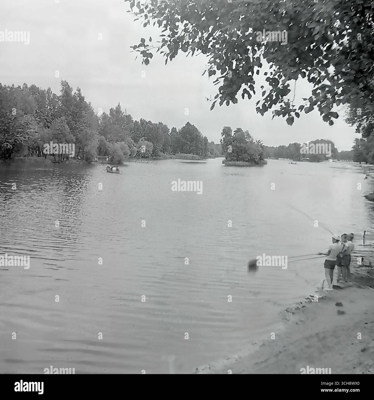 Eine ruhige Szene des Sommerfischens an einem ruhigen Ufer des Sewerski Donets in Swiatohirsk während der Sowjetzeit, um die 1970er Jahre Männer mit Angelruten genießen die Ruhe abseits der belebten Touristenstrände. Das Foto ist ein klassisches Bild von Sommerurlaub und Freizeitaktivitäten am Wasser, das das nicht-zeremonielle tägliche Leben des berühmten Resorts widerspiegelt. Es handelt sich um ein nostalgisches und wertvolles Dokument, das die Atmosphäre der Friedlichkeit und des friedlichen Lebens im Donbass vor dem Krieg erfasst Stockfoto