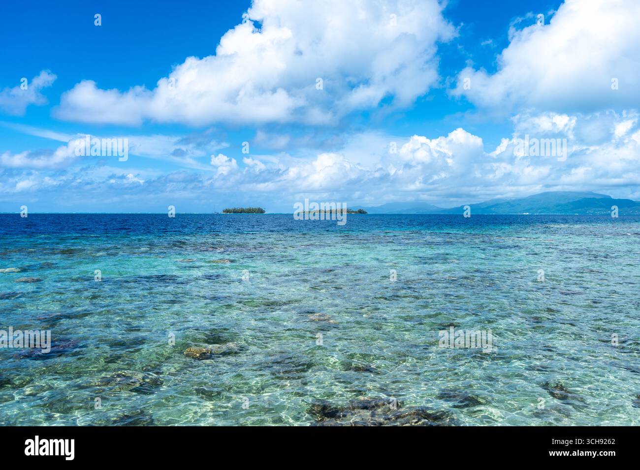 Klares blaues Wasser umgeben das Motus- und Korallenriff der Insel Tahaa und bietet einen malerischen Blick auf die Lagune in Französisch-Polynesien Stockfoto