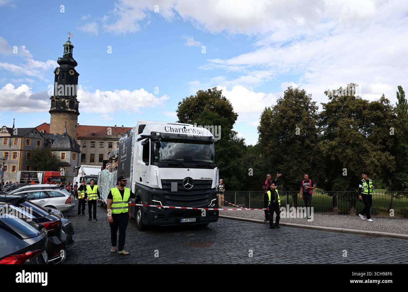 Weimar 30.08.2025, Weimar, kultureller Umzug in Anlehung an CSD und Loveparade, hier werden LKW, die am Umzug teilnehmen, durch Security mit Absperrband gesichert *** Weimar 30 08 2025, Weimar, Kulturparade im Stil von CSD und Loveparade, hier werden LKW, die an der Parade teilnehmen, durch Sicherheit mit Absperrband gesichert Stockfoto