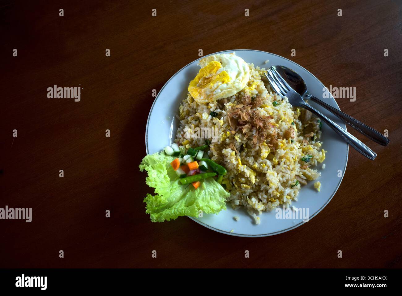Nasi Goreng, gebratener Reis, traditionelle indonesische Küche, mit Hühnereier und Gemüse auf einem weißen Teller. Indonesische Küche. Stockfoto