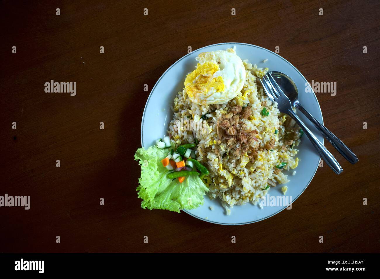 Nasi Goreng, gebratener Reis, traditionelle indonesische Küche, mit Hühnereier und Gemüse auf einem weißen Teller. Indonesische Küche. Stockfoto