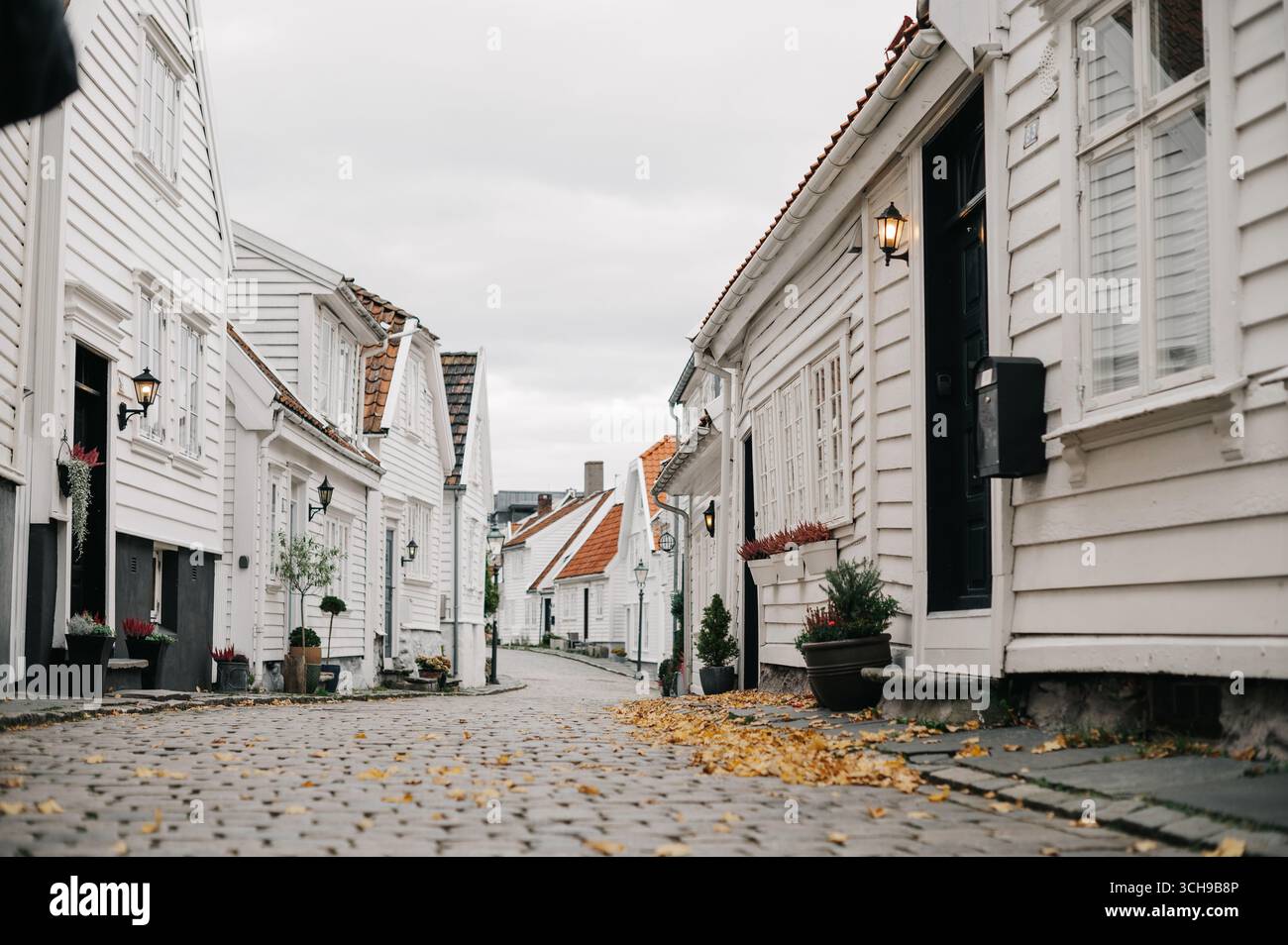 Leere Herbststraße mit Pflastersteinstraße weißen Häusern Stockfoto