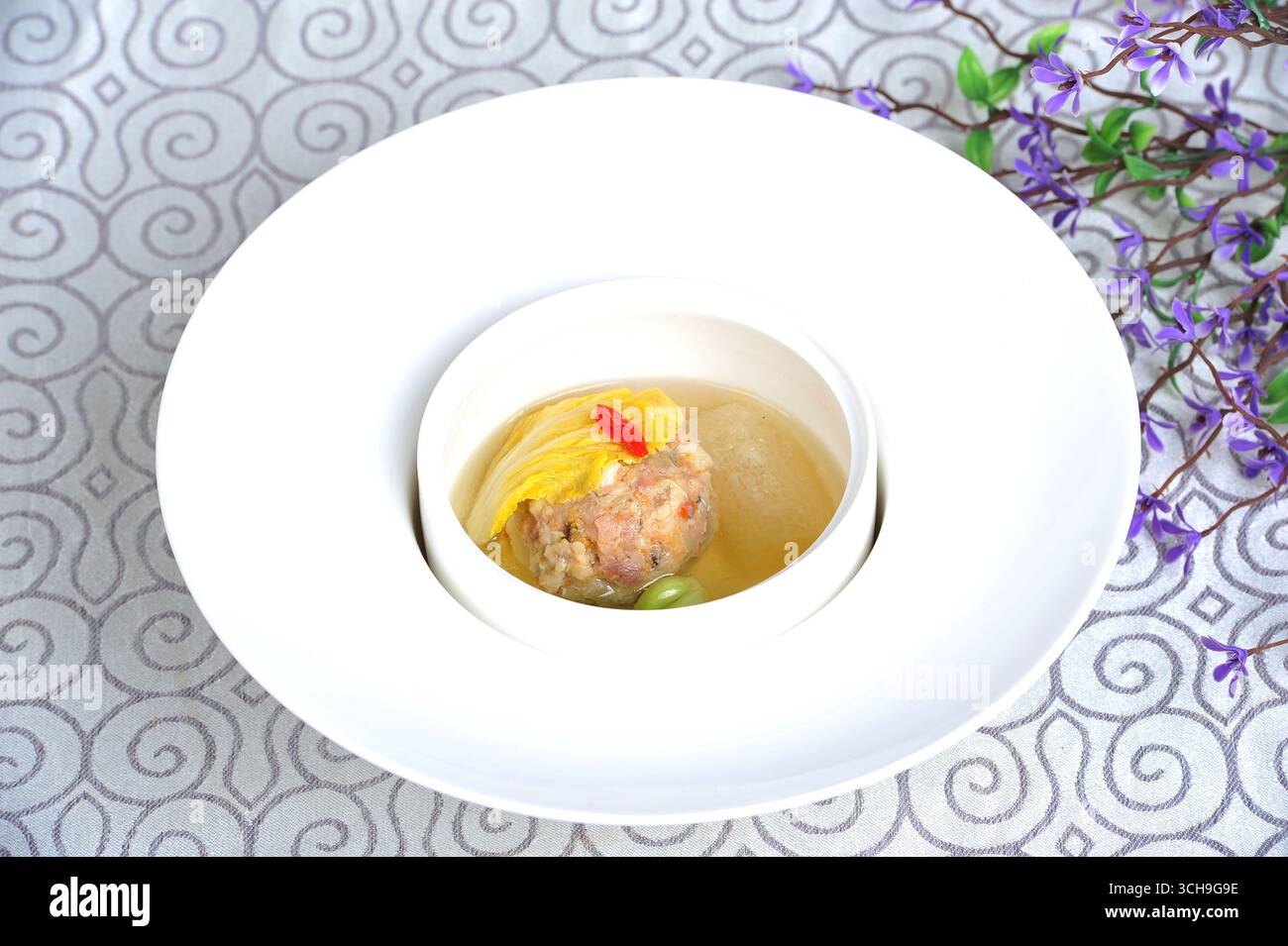 Chinesischer Huaiyang Lion's Head Schweinefleischkugel in klarer Brühe auf weißer Platte Stockfoto