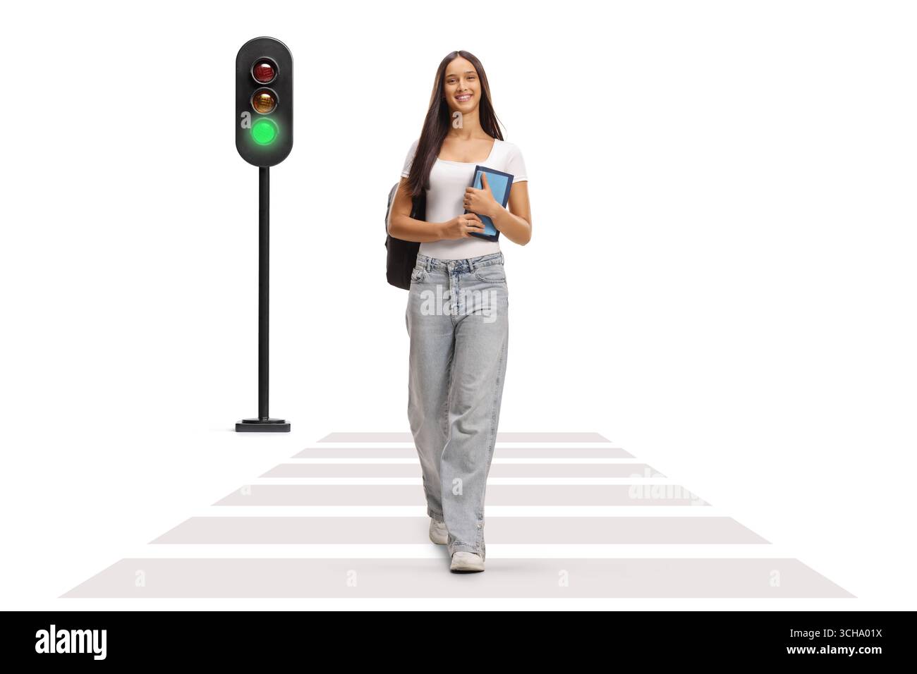 Schöne weibliche Teenager-Studentin, die an einer Zebraüberquerung und einer grünen Ampel auf weißem Hintergrund läuft Stockfoto