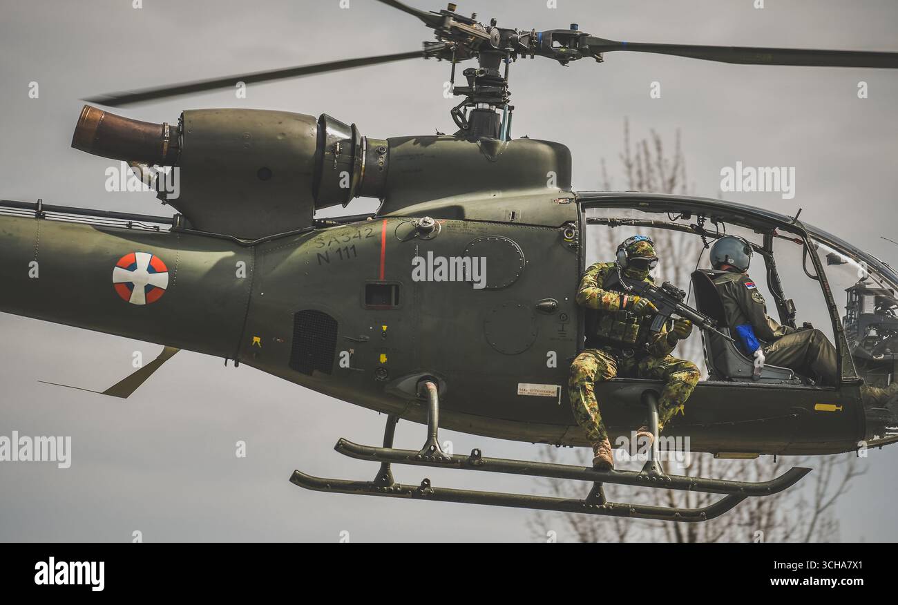 Gazelle Militärhubschrauber mit sichtbarem Piloten und Soldaten der Spezialkräfte bewaffnet mit einem automatischen Gewehr Stockfoto