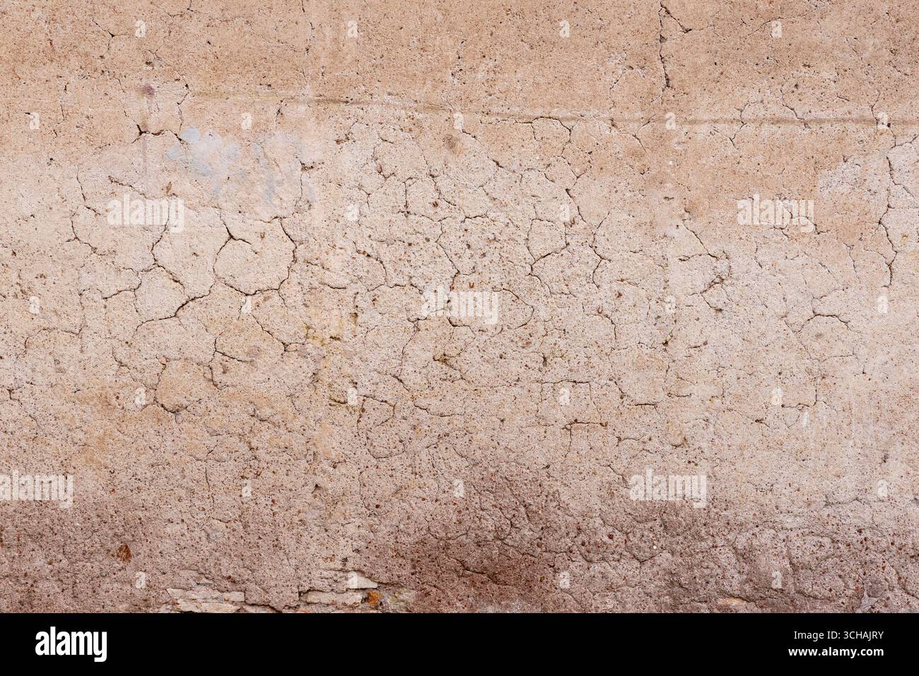 Nahaufnahme einer rissigen Putzwandoberfläche mit natürlicher Textur und rauen Details Stockfoto