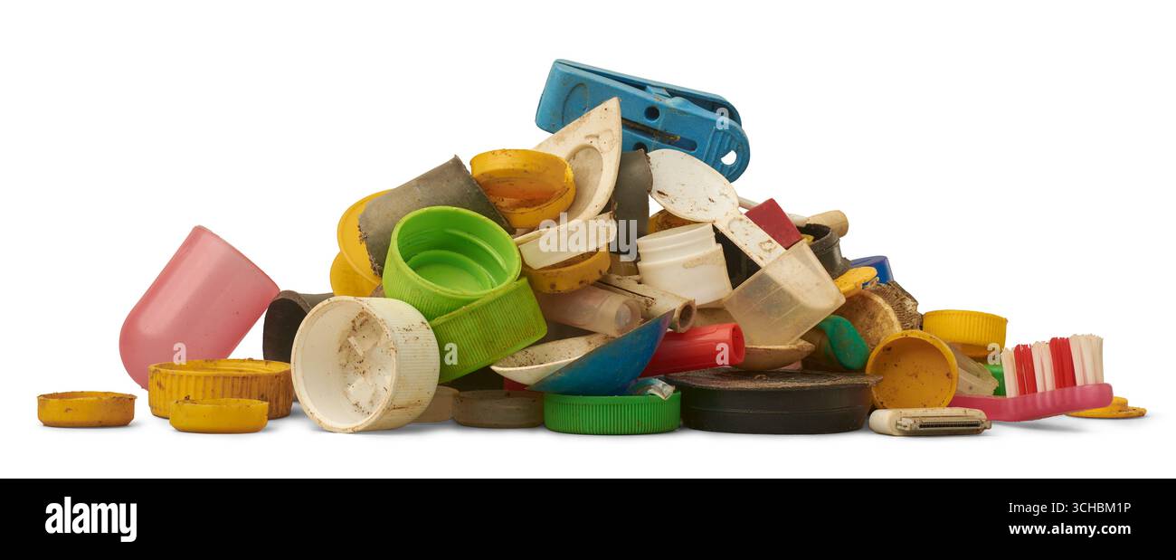Stapel von verschmutzten, verwitterten Kunststoffabfällen einschließlich Flaschenverschlüssen, Spielzeugteilen, Zahnbürste und Fragmenten isolierter weißer Hintergrund, Verschmutzung und Umwelt Stockfoto