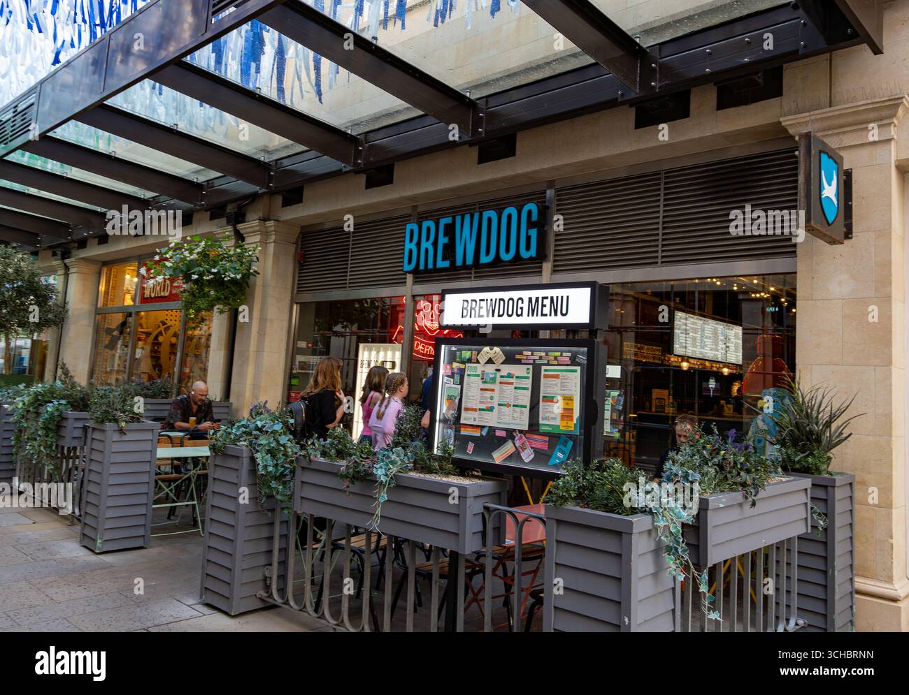 Blick auf ein BrewDog Restaurant mit Leuten, die draußen unter einem Baldachin sitzen und Drinks und Gespräche genießen. Southgate Bad Stockfoto