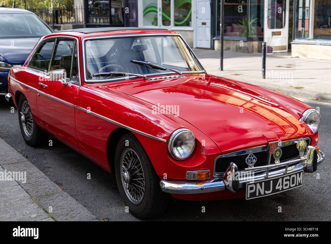 Klassischer, roter MG BGT-Oldtimer mit Chromakzenten, der auf einer Straße in der historischen Stadt Bath Somerset, Großbritannien, geparkt ist Stockfoto