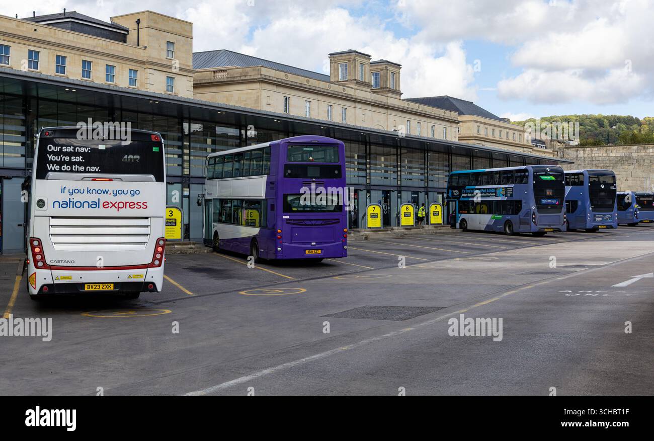 Badebushaltestelle mit verschiedenen Bussen, darunter National Express und Doppeldeckerbusse, vor einem Hintergrund historischer Architektur Stockfoto